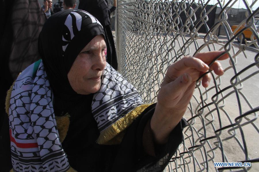 A Palestinian woman waits for the return of members of Fatah movement at the Rafah crossing with Egypt in the southern Gaza Strip, on Dec. 3, 2012. A total of 11 members of Palestinian Fatah movement, who fled Gaza into Egypt in 2007 during internal fighting between the two political rivals, returned home on Monday following an amnesty by the Hamas ruling government. (Xinhua/Khaled Omar) 