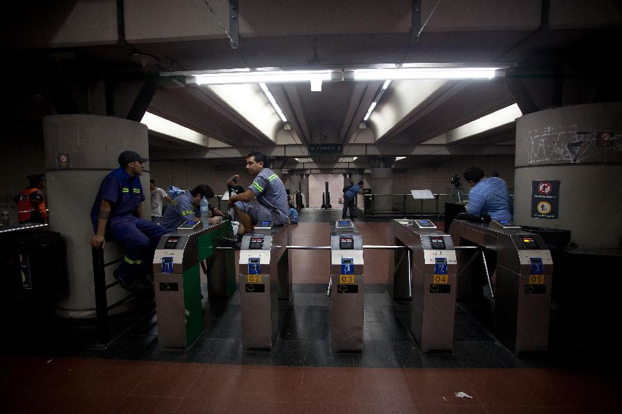 Subway employees are seen on an empty platform during a strike in Buenos Aires, capital of Argentina, on Dec. 3, 2012. As a result of disputes between union factions, vying for the representation of workers, the Tramway and Motorized Drivers Union (UTA) decreed a total stoppage in the six subway lines and Premetro, according to local press. (Xinhua/Martin Zabala) 