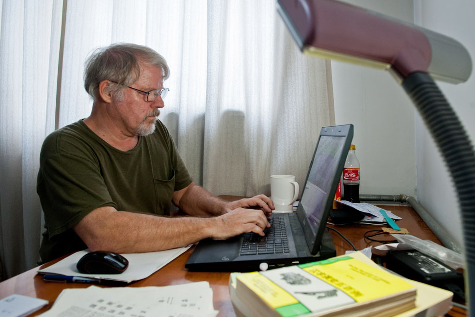 Richard Sears updates his website in his single-room apartment in Tianjin, north China, Aug. 8, 2012.(Xinhua Photo)