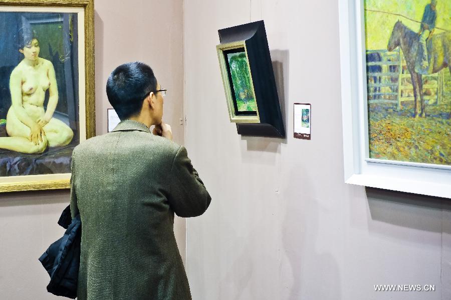 A man looks at a painting displayed during the preview of Beijing Council 2012 Autumn Auction held in Beijing International Hotel Convention Center in Beijing, capital of China, Dec. 3, 2012. The preview, which kicked off on Sunday, showcased over 2500 artworks of different varieties such as paintings, chinaware and sculptures. The auction will last from Dec. 5 to Dec. 7. (Xinhua/Zhang Cheng)