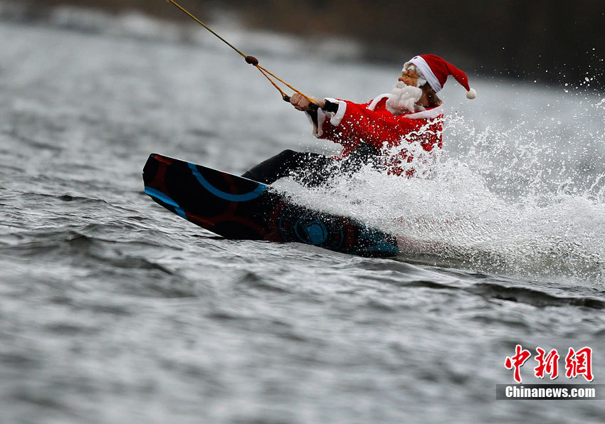 A tourist dressed as Santa Claus surfs in a lake in Hamburg, Germany.(Photo/Chinanews.com)