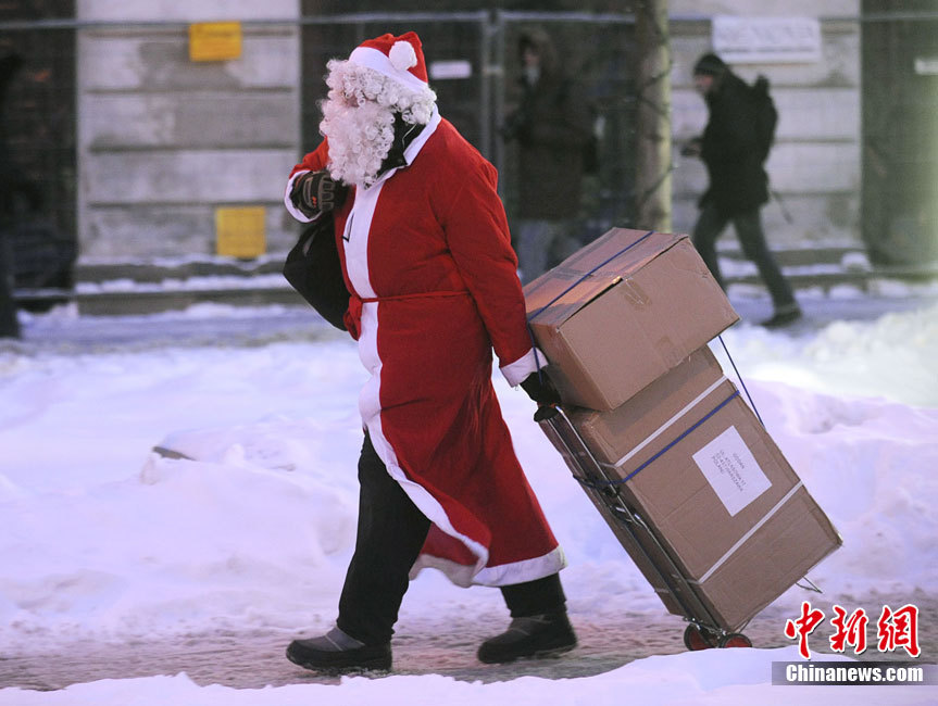  A “Santa Claus” , dragging a bag of Christmas presents, walks on the street in Poland, Warsaw.(Photo/Chinanews.com)