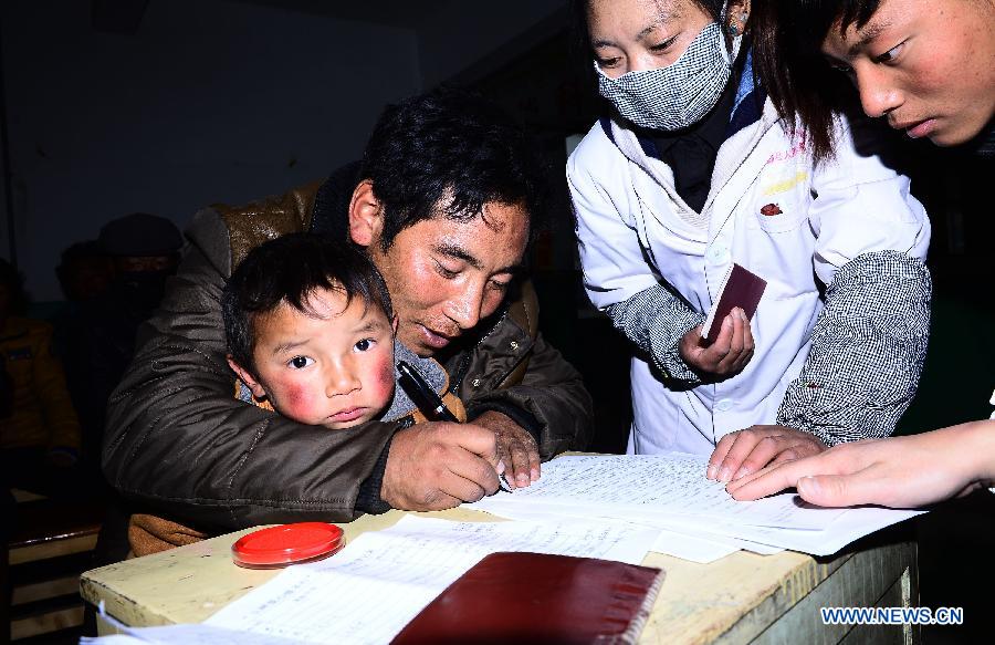 Chagba (2nd L), father of Luozhou Jigme, a child with congenital heart disease, signs on a consent of operation in Nangqian County, northwest China's Qinghai Province, Dec. 3, 2012. More than 500 children here will receive free heart disease test by doctors from Anhui Red Cross Cardiovascular Hospital and 15 children with congenital heart disease will be treated for free in Hefei, capital of east China's Anhui Province. (Xinhua/Zhang Hongxiang) 
