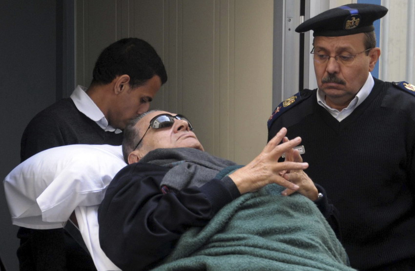 Former Egyptian President Mubarak lies on a gurney bed while leaving the court where he stands trial on Jan. 1, 2012. (Photo/Reuters)