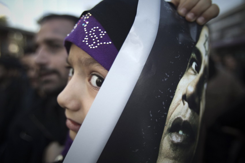 An Iran girl holds an anti-American placard with an image of U.S. president Obama during the funeral ceremony for Iranian nuclear scientist Mustafa, Jan 1, 2012. (Reuters/Morteza Nikoubazl)