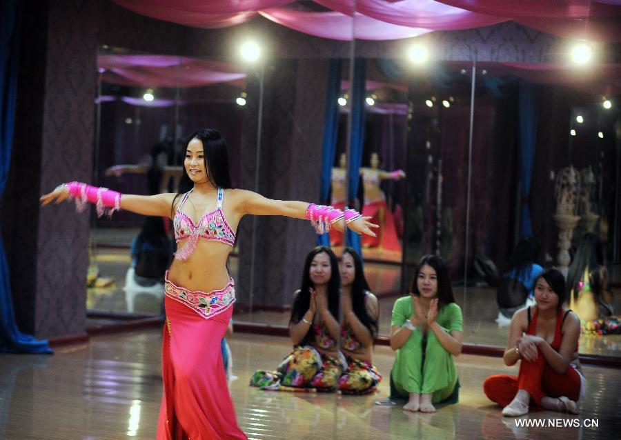 Belly dance trainer Guan Fang demonstrates for her students in Taiyuan, capital of north China's Shanxi Province, Dec. 3, 2012. Belly dance became more and more popular among China's young people as a means of physical exercises. (Xinhua/Yan Yan)