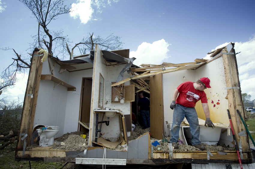 Tim Keaomu clears up debris from a damaged house ruined by tornado in Lowa Thurmann on April 15, 2012. (Reuters/Lane Hickenbottom)