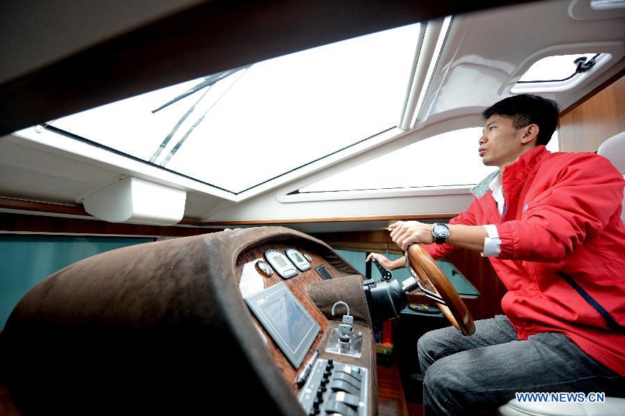 A staff member drives a solar yacht on the Yundang Lake in Xiamen, southeast China's Fujian Province, Dec. 5, 2012. The 15-meter-long and 6-meter-wide solar yacht was put into use on Wednesday. The yacht can transform the collected solar energy into electricity to provide power supply for the facilities on board. (Xinhua/Zhang Guojun) 