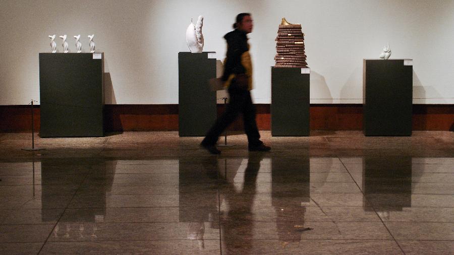 A visitor walks past the exhibits at the 1st China Contemporary Ceramics Art Exhibition at Beijing World Art Museum of the China Millennium Monument, in Beijing, capital of China, Dec. 5, 2012. The exhibition, which opened on Wednesday, will last until Dec. 11. (Xinhua/Zhai Jianlan) 