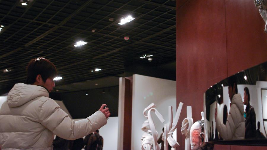 A visitor takes photos at the 1st China Contemporary Ceramics Art Exhibition at Beijing World Art Museum of the China Millennium Monument, in Beijing, capital of China, Dec. 5, 2012. The exhibition, which opened on Wednesday, will last until Dec. 11. (Xinhua/Zhai Jianlan)