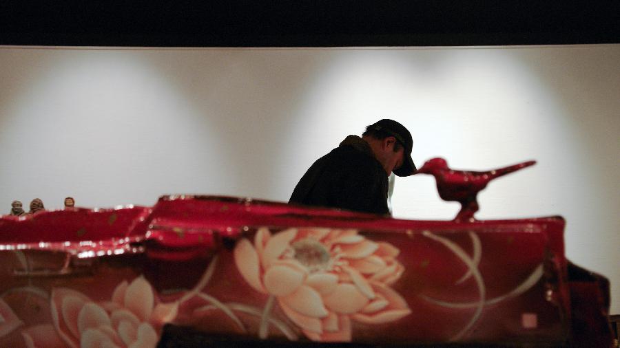 A visitor views an exhibit at the 1st China Contemporary Ceramics Art Exhibition at Beijing World Art Museum of the China Millennium Monument, in Beijing, capital of China, Dec. 5, 2012. The exhibition, which opened on Wednesday, will last until Dec. 11. (Xinhua/Zhai Jianlan)