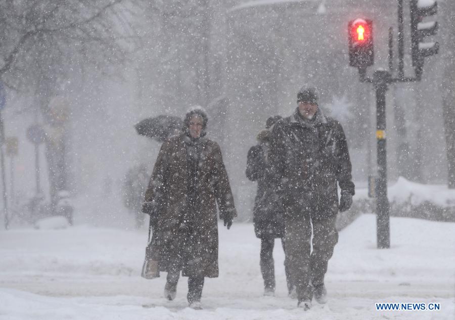 People walk in heavy snow in Stockholm, capital of Sweden on Dec. 5, 2012. Stockholm's traffic was affected by the bad weather on Wednesday. (Xinhua/Wu Wei) 
