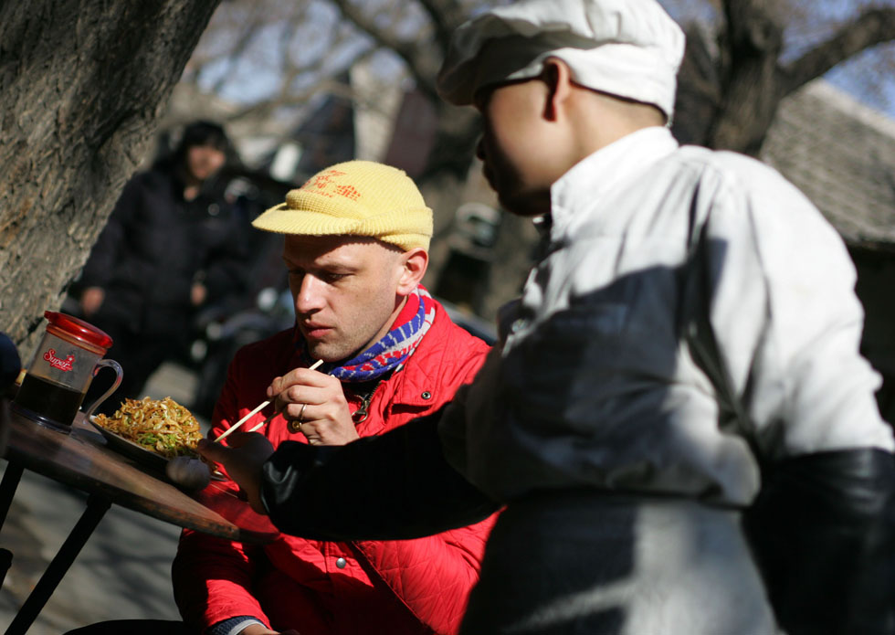 Johnson-Hill has lunch in an alley near Nanluoguxiang of Beijing, capital of China, March 6, 2012. 