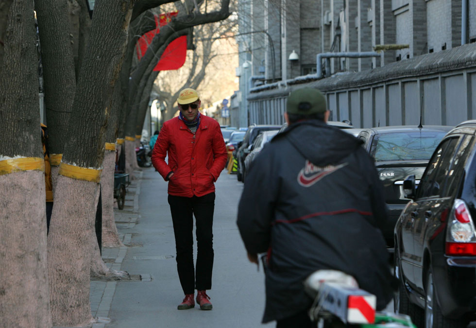 Johnson-Hill (L) walks in Beibingmasi alley near Nanluoguxiang of Beijing, capital of China, March 6, 2012.