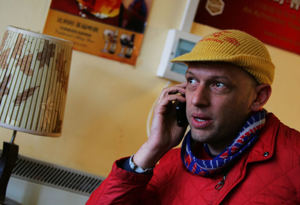 Johnson-Hill answers a call at a coffee bar in Nanluoguxiang of Beijing, capital of China, March 6, 2012.
