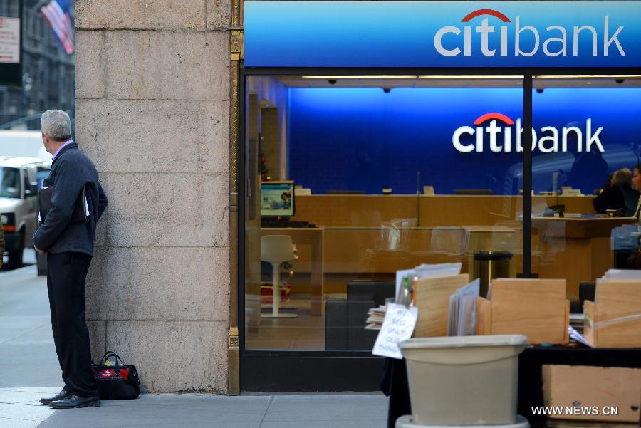 A man stands outside a Citibank branch in New York, the United States, Dec. 5, 2012. Citigroup announced on Wednesday that it would slash 11,000 jobs, or roughly 4 percent of its current workforce, in an effort to cut costs. (Xinhua/Wang Lei) 