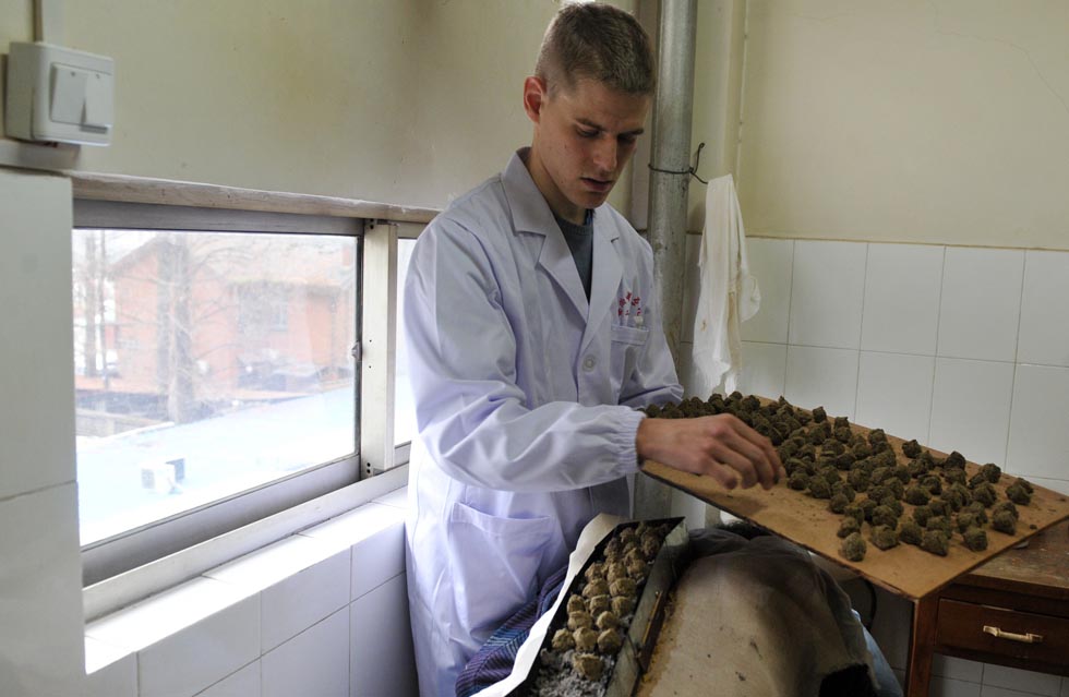 Florian Paillard places the moxa as he conducts moxibustion therapy to a patient at the Acupuncture and Moxibustion Hospital of Anhui University of Traditional Chinese Medicine in Hefei, capital of east China's Anhui Province, Feb. 13, 2012.(Xinhua/Liu Junxi)