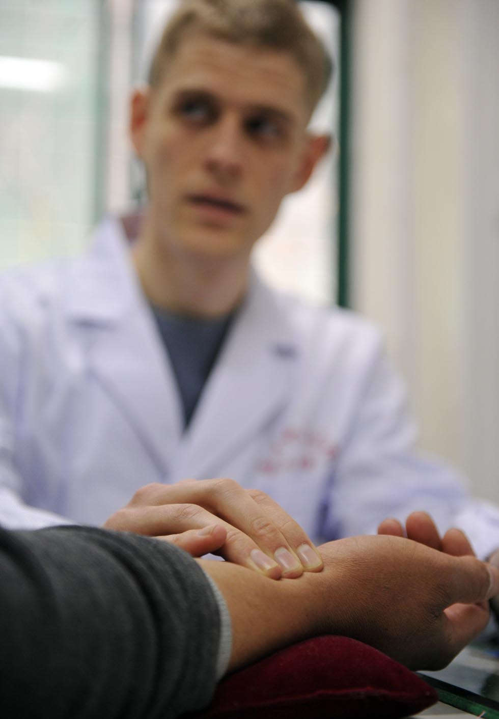 Florian Paillard takes the pulse for a patient at the Acupuncture and Moxibustion Hospital of Anhui University of Traditional Chinese Medicine in Hefei, capital of east China's Anhui Province, Feb 13, 2012.(Xinhua/Liu Junxi)