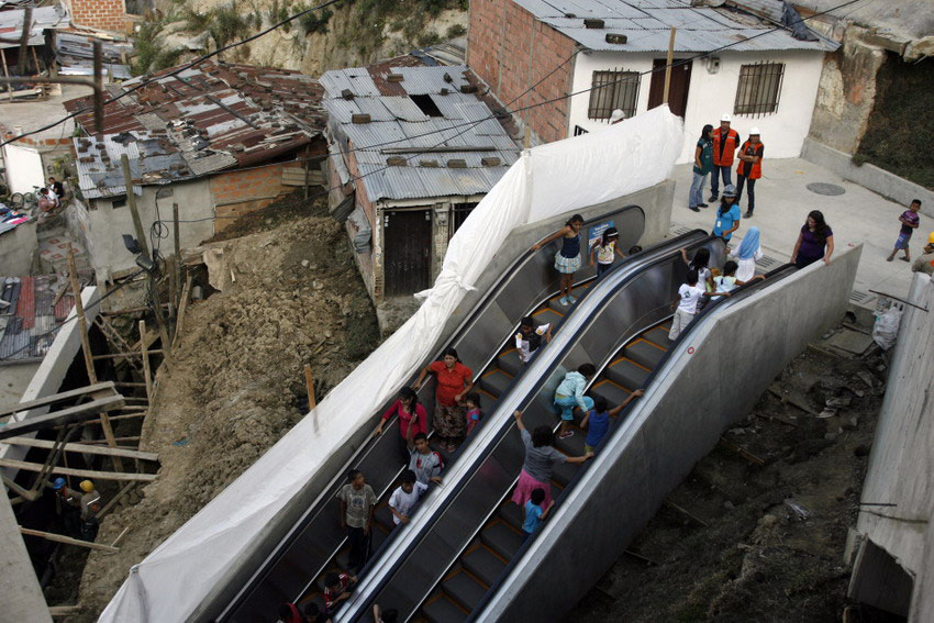People go out on an outdoor public escalator on Commune 13 in Medellin on Jan 12, 2012. The 384-meter-long outdoor escalator is installed by the government in the poorest district of Colombia’s second largest city, to facilitate 12,000 people traveling. (Reuters/Fredy Builes)