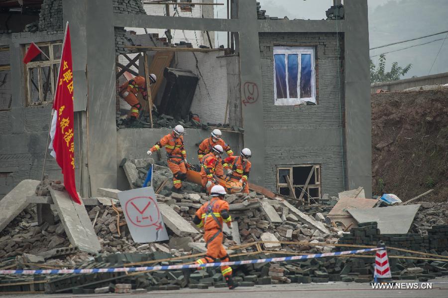 Fire fighters conduct a rescue operation at a simulated earthquake site during a joint search and rescue exercise in Chongqing, southwest China, Dec. 6, 2012. The joint exercise was held on Thursday to celebrate that the National (Chongqing) Land Search and Rescue Base was officially put into service. (Xinhua/Chen Cheng)
