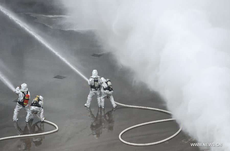 Fire fighters put out a fire during a joint search and rescue exercise in Chongqing, southwest China, Dec. 6, 2012. The joint exercise was held on Thursday to celebrate that the National (Chongqing) Land Search and Rescue Base was officially put into service. (Xinhua/Chen Cheng)