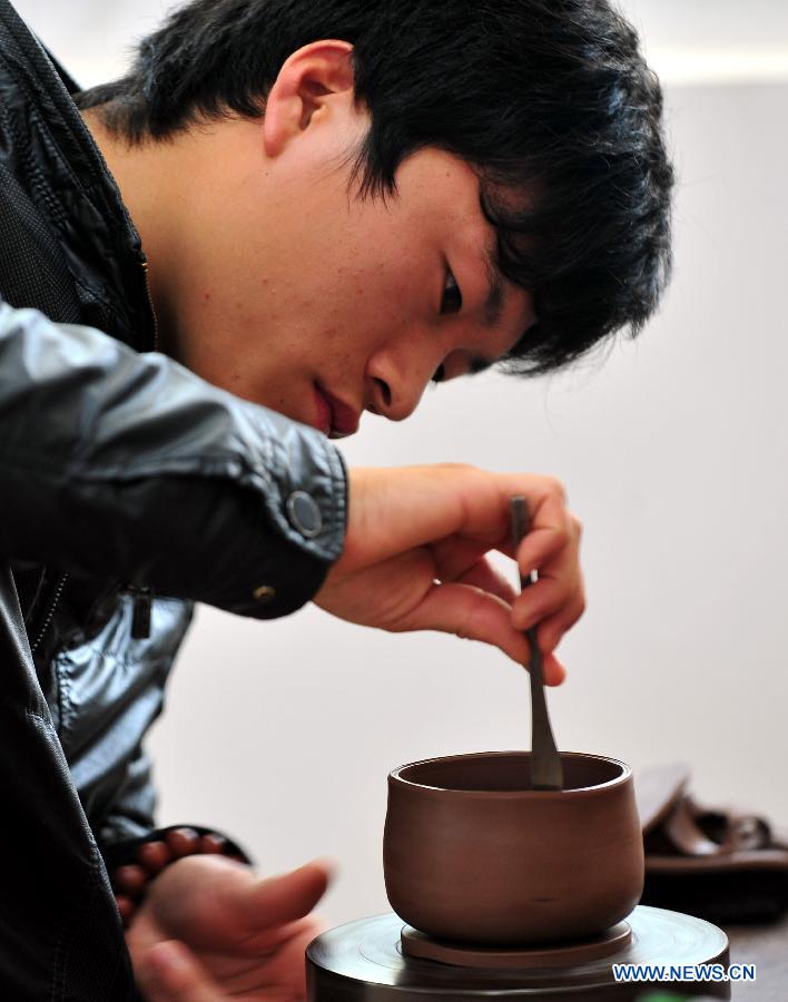 A contestant makes a ceramic cup during a contest for ceramics-making in Qinzhou City, south China's Guangxi Zhuang Autonomous Region, Dec. 6, 2012. Altogether 142 contestants took part in the event. (Xinhua/Chen Ruihua) 