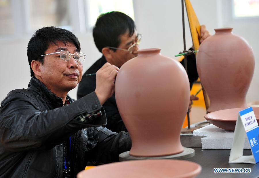 Contestants carve on ceramic bottles during a contest for ceramics-making in Qinzhou City, south China's Guangxi Zhuang Autonomous Region, Dec. 6, 2012. Altogether 142 contestants took part in the event. (Xinhua/Chen Ruihua)
