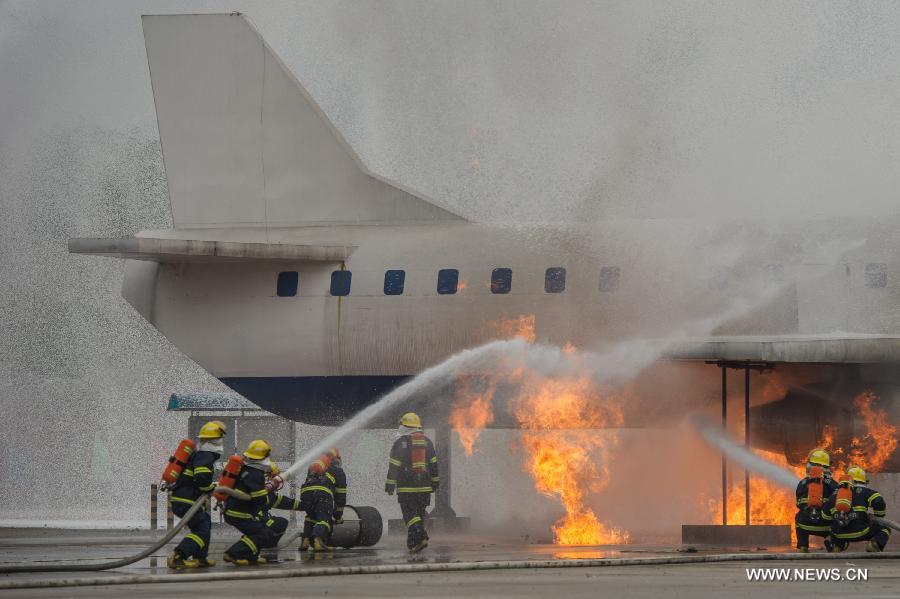Fire fighters put out a simulated plane's fire during a joint search and rescue exercise in Chongqing, southwest China, Dec. 6, 2012. The joint exercise was held on Thursday to celebrate that the National (Chongqing) Land Search and Rescue Base was officially put into service. (Xinhua/Chen Cheng)