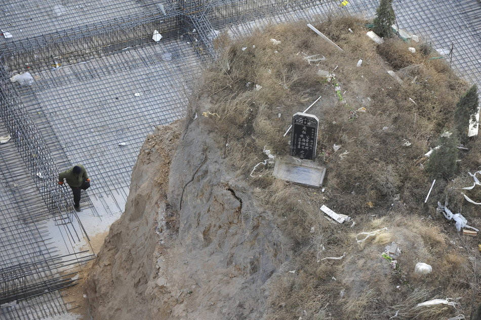 A lone tomb stands on a hillock at the construction site of a residential apartment project in Taiyuan on Dec, 5. 2012. (Yu Wei/ Icpress)