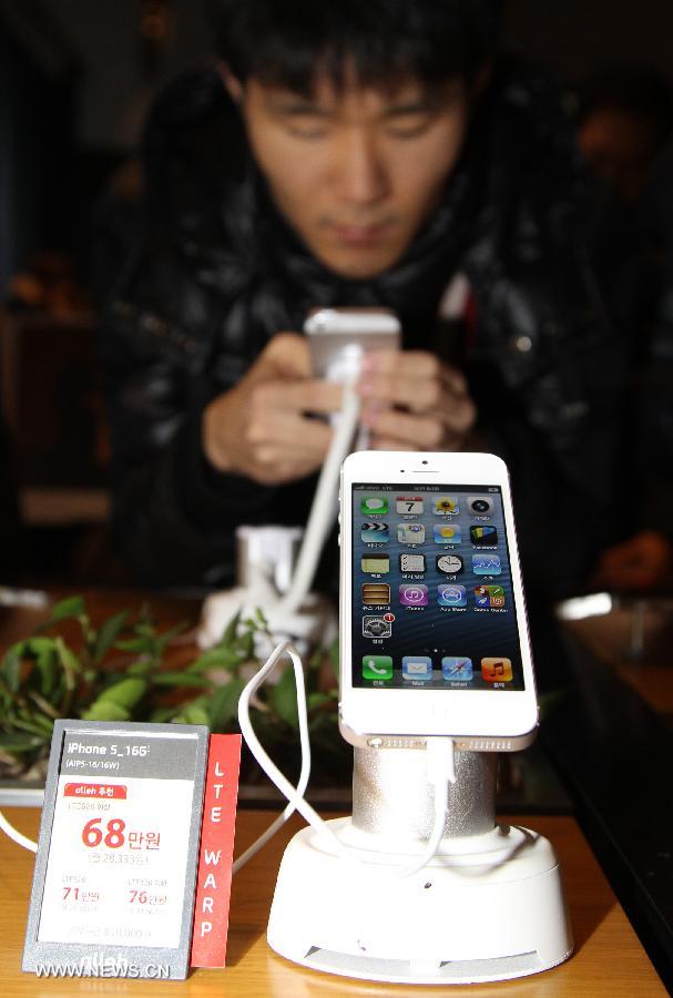 A South Korean customer plays with the iPhone 5 during the iPhone 5 launch event in Seoul, South Korea, Dec. 7, 2012. (Xinhua/Park Jin-hee)
