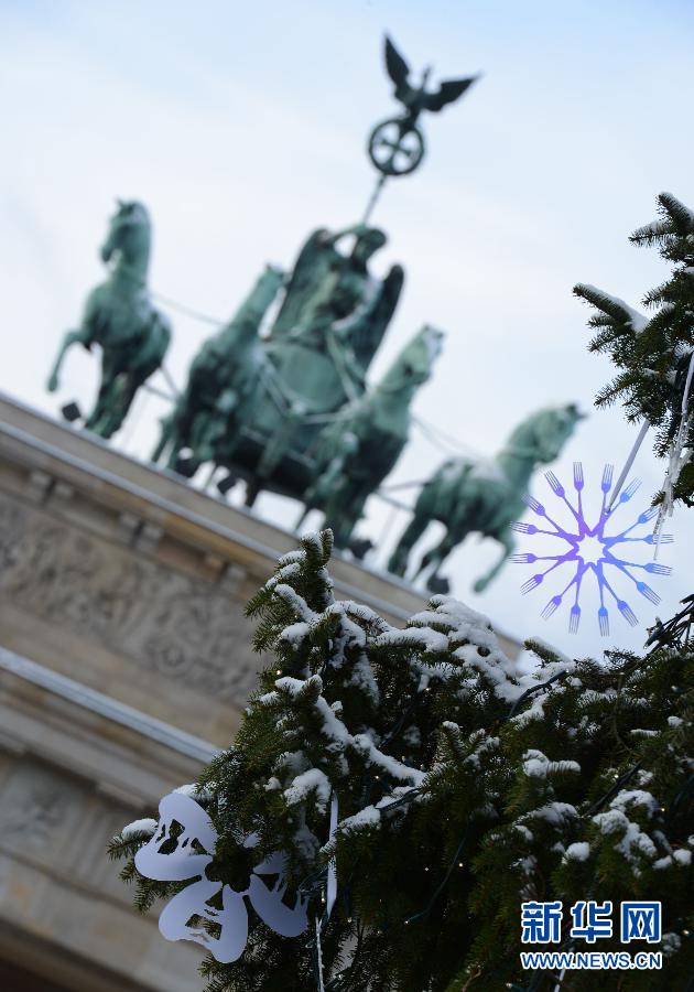 Christmas stars hanging on Christmas trees in front of the Brandenburg Gate Dec. 6, 2012. Berlin had its first heavy snow since winter on that day. (Xinhua/Ma Ning)