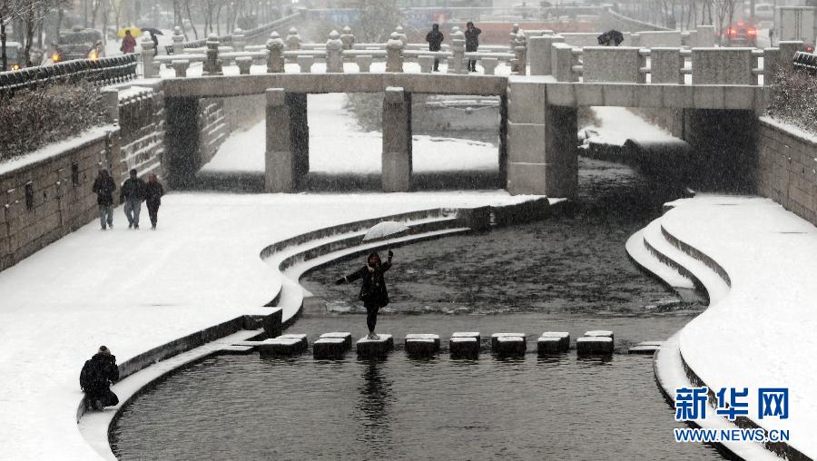 A tourist takes photos in snow in Seoul on Dec. 5, 2012. Seoul was hit by a heavy snow on that day. The local police department has issued the “traffic security emergency alarm”, to deal with the possible traffic issues caused by the heavy snow. (Xinhua/Yao Qilin)