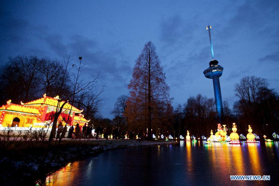 Visitors enjoy the Chinese Light Festival in Rotterdam on Dec. 6, 2012. The festival, including 35 illuminated figures, will last to February 14th of next year.(Xinhua/Rick Nederstigt)