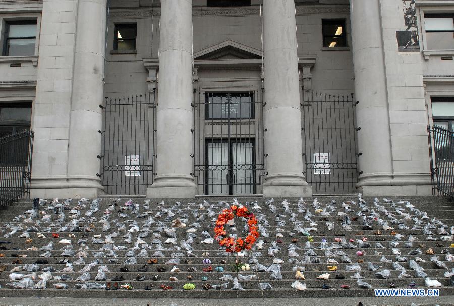 Hundreds of women's shoes cover the steps of Vancouver Art Gallery during annual Shoe Memorial in Vancouver, Canada, Dec. 6, 2012. December 6th is Canada's National Day of Mourning for women who have met with violent deaths. Shoes in bags represent dead women, and those without bags represent women who are alive but suffer from abuse. (Xinhua/Sergei Bachlakov)