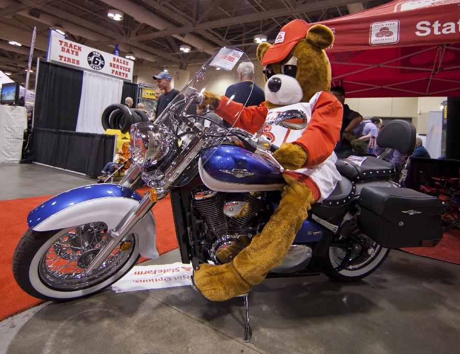 A costumed mascot poses for photos with a motorcycle during the 2012 Toronto Motorcycle Show at the Metro Toronto Convention Centre in Toronto, Canada, Dec. 8, 2012. The three-day event displays hundreds of new 2013 motorcycles, scooters from the world's top manufacturers from Dec. 7 to 9 this year. (Xinhua/Zou Zheng) 