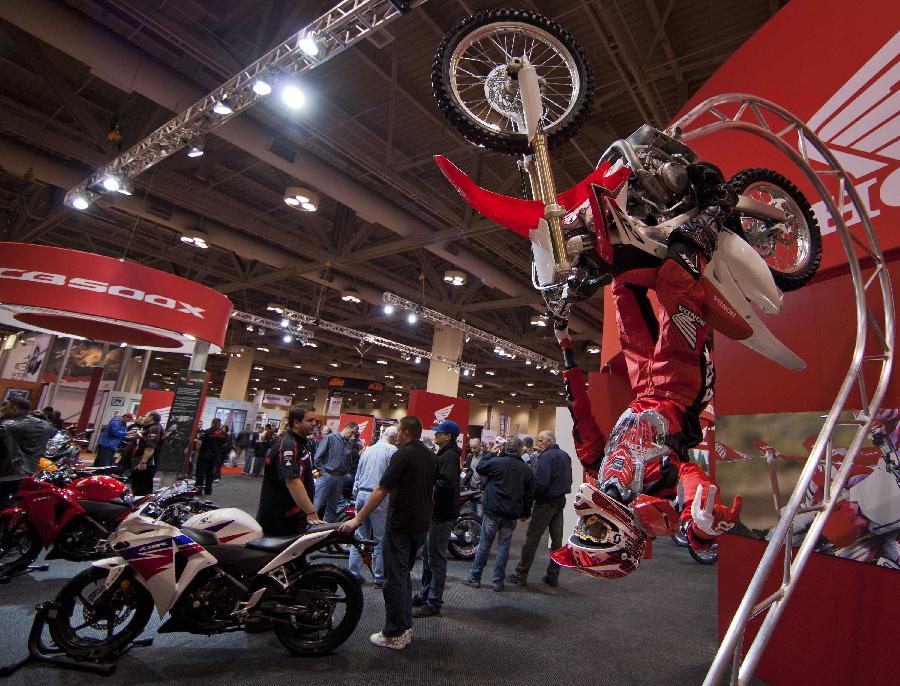 Visitors watch displayed motorcycles during the 2012 Toronto Motorcycle Show at the Metro Toronto Convention Centre in Toronto, Canada, Dec. 8, 2012. The three-day event displays hundreds of new 2013 motorcycles, scooters from the world's top manufacturers from Dec. 7 to 9 this year. (Xinhua/Zou Zheng) 