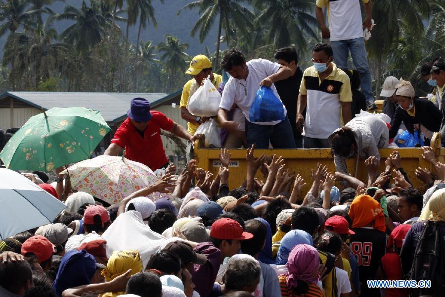 Typhoon-affected residents wait for relief food in a heavily damaged town of New Bataan of Compostela Valley Province, the Philippines, Dec. 9, 2012. The death toll from Typhoon Bopha (locally known as Pablo) has climbed to 540 and 827 others are still missing, official statistics released Sunday showed. (Xinhua/JEMA)  