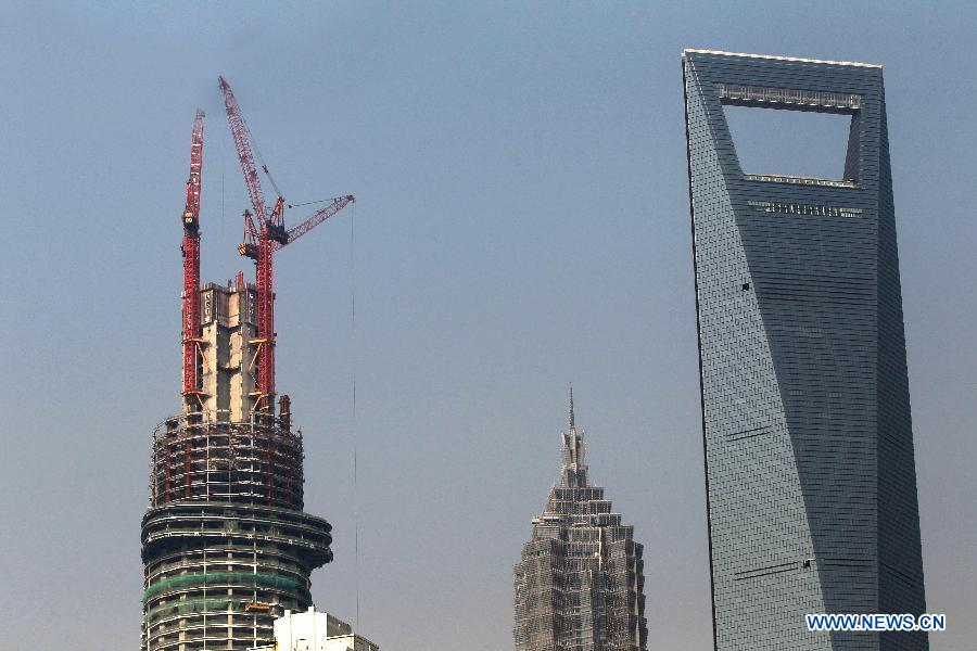 Photo taken on Dec. 8, 2012 shows the Shanghai Tower (L), a skyscraper under construction, along with the neighbouring Jin Mao Tower (C) and the Shanghai World Financial Center in Pudong, east China's Shanghai Municipality. The Shanghai Tower is expected to reach 632 meters in height and start service in 2015. (Xinhua/Pei Xin)