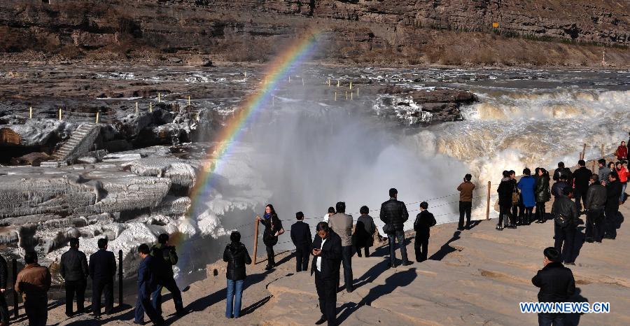 Tourists view a rainbow over the Hukou Waterfalls, a section of the middle reaches of the Yellow River, in Linfen, north China's Shanxi Province, Dec. 8, 2012. Icicles have been formed on the Hukou Waterfalls recently due to low temperature. Hukou Waterfalls are located on the border of Shanxi and northwest China's Shaanxi Province. (Xinhua/Lv Guiming)