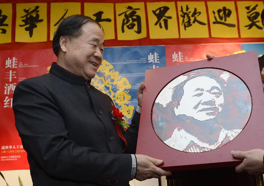 Chinese writer Mo Yan, the 2012 Nobel Prize winner for literature, receives a gift during a reception by Chinese entrepreneurs in Stockholm, capital of Sweden, Dec. 8, 2012. (Xinhua/Wu Wei)