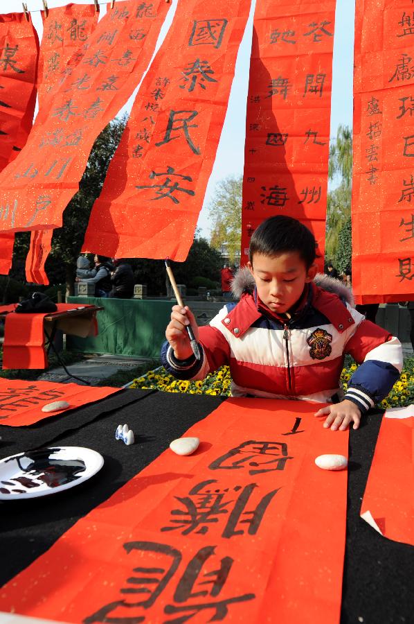 A boy writes Chinese characters to express his wishes for the New Year in the youth center of Hangzhou, capital of east China's Zhejiang Province, Dec. 9, 2012. In total 30 boys and girls who were the prize winners of the 2nd "Xinmiao" Award of children's calligraphy participated in this activity, works of whom will be sent to welfare agencies like nursing homes. (Xinhua/Ju Huanzong)