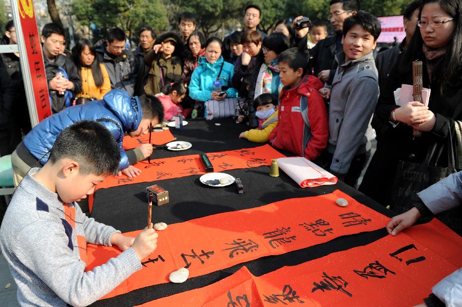 Children write Chinese characters to express their wishes for the New Year in the youth center of Hangzhou, capital of east China's Zhejiang Province, Dec. 9, 2012. In total 30 boys and girls who were the prize winners of the 2nd "Xinmiao" Award of children's calligraphy participated in this activity, works of whom will be sent to welfare agencies like nursing homes. (Xinhua/Ju Huanzong)