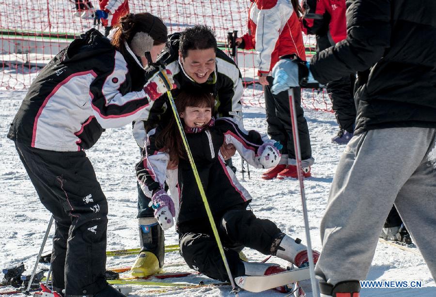 A woman (C) falls off while skiing at "Kuangbiao Leyuan" park in Beijing, capital of China, Dec. 9, 2012. As the temperature continued to decrease, Beijing has entered skiing boom season. (Xinhua/Zhang Yu) 