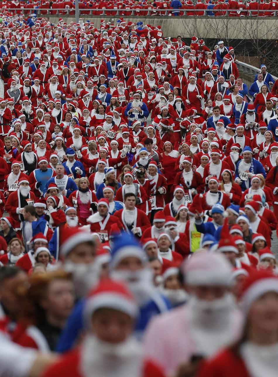 People dress up as Santa Claus to attend the annual Santa Claus jogging in Liverpool, northern Britain, Dec. 2, 2012. (Xinhua/Reuters)