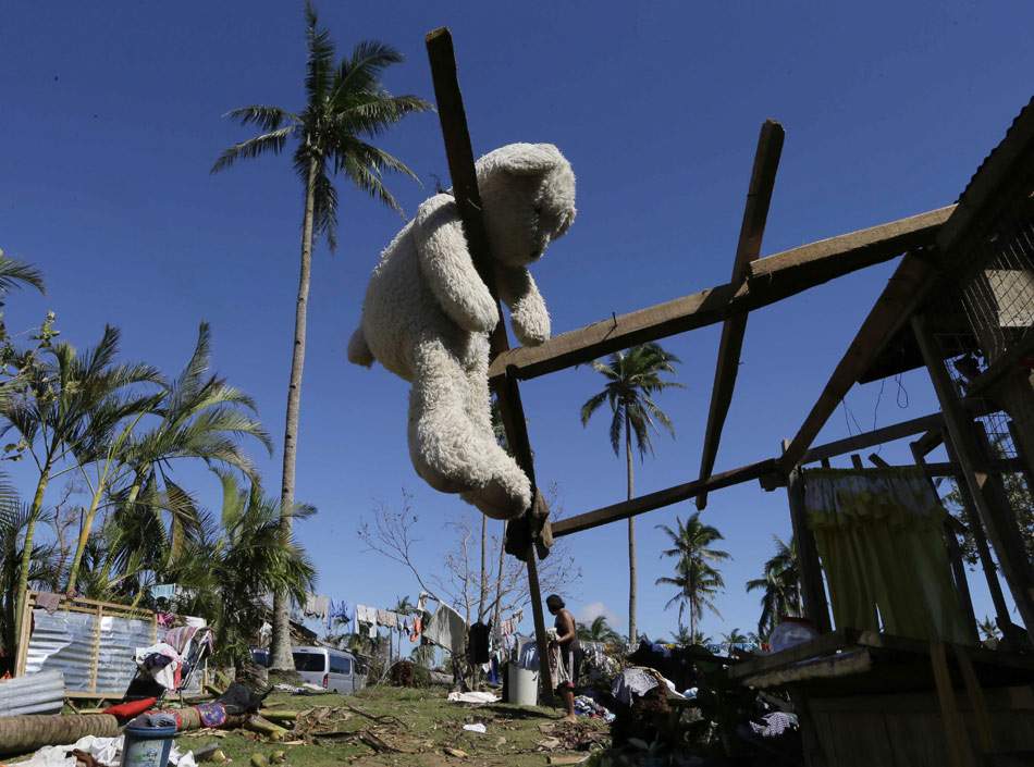 A teddy bear is hung on a piece of wood to dry in the air in New Bataan of Compostela Valley Province, the Philippines, Dec. 8, 2012. Typhoon Bopha has left 459 dead, 30 provinces affected in the country. The victims have reached 5.4 million and the total economic loss outnumbered 4.1 billion pesos (about 100 million dollars).  (Xinhua/ AP)