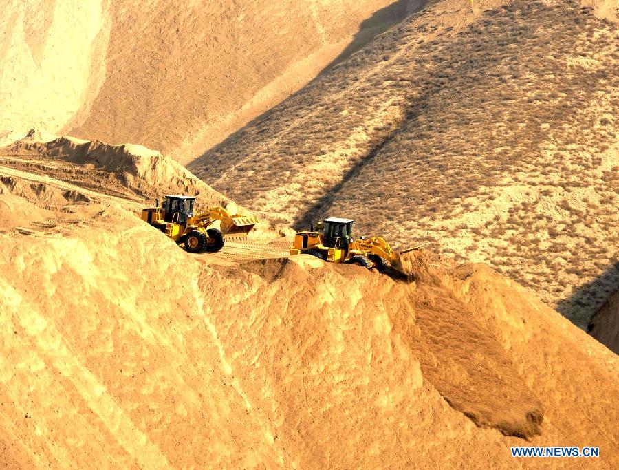 Construction vehicles work at a hilly region in Lanzhou, capital of northwest China's Gansu Province, Dec. 10, 2012. A project of land development has been under construction here since this October as the city planned to remove some of its barren hills to provide land of 25 square kilometers in half a year for city development. (Xinhua/Nie Jianjiang) 