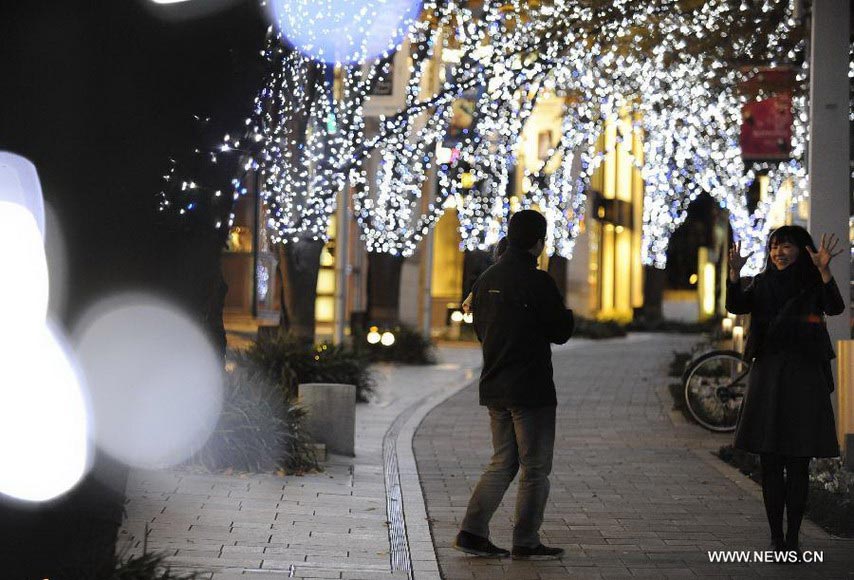 People walk on a street decorated by Christmas lights in Roppongi of Tokyo, capital of Japan, Dec. 10, 2012. (Xinhua/Kenichiro Seki)