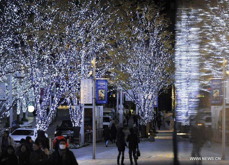 People walk on a street decorated by Christmas lights in Roppongi of Tokyo, capital of Japan, Dec. 10, 2012. (Xinhua/Kenichiro Seki)