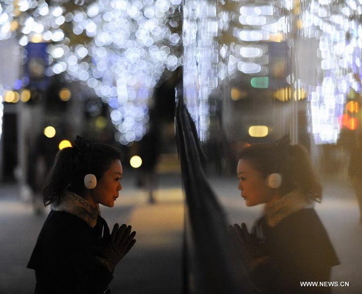 A visitor looks at the decorations made for the approaching Christmas in Roppongi of Tokyo, capital of Japan, Dec. 10, 2012. (Xinhua/Kenichiro Seki)  