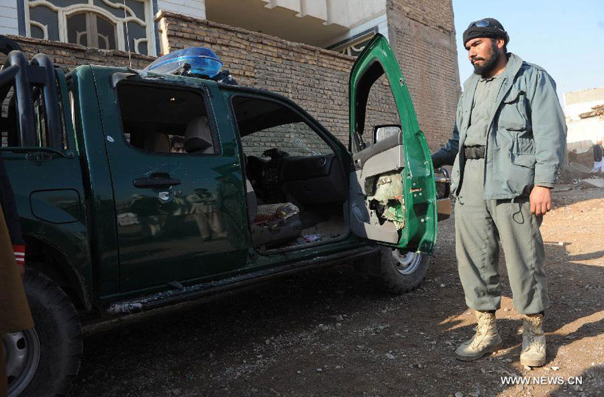An Afghan policeman opens a door of a vehicle on which the police chief of Nimroz province Mohammad Musa Rasouli was killed in Herat, Afghanistan, on Dec. 10, 2012. The police chief was killed Monday in a blast in the neighboring Herat province, a police spokesman said. (Xinhua/Sardar) 
